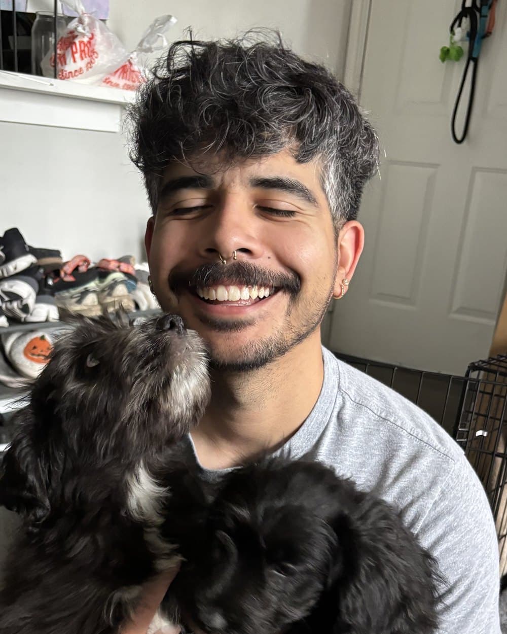 Jason Guzman, smiling, holding his two dogs.